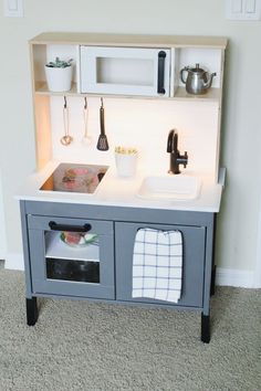 a toy kitchen with sink, stove and microwave