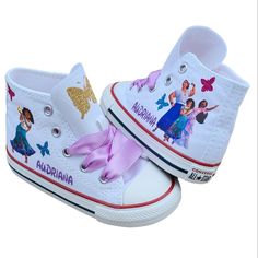 One shoe has Mirabel and the other has all three sisters. Butterflies on tongues and sides of shoes as shown. Her name on both shoes in purple glitter. Encanto Shoes, Converse For Girls, Mickey Mouse Converse, Personalized Converse, Converse Star, Three Sisters, Purple Glitter, No Name