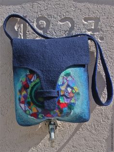 a blue purse hanging on the side of a wall