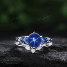 "This is a 1.3 carat Lab blue star sapphire engagement ring in solid gold,about 7mm round cut. The accent stones are pear 3x4mm lab sapphires. The wedding band stones are lab opals. The band width is about 1.3-1.4mm. It can be made in any ring size. However please contact me to custom make it to a special big or small size. It can be made in white gold,rose gold or yellow gold with 14k or 18k. However for some people who are nickel allergic,I can also make it to 925 sterling silver to make you can wear it. The ring is handmade,very high quality! 30 days money back guarantee. Returns & Warranty 30-Day money back guarantee (starting from the day of delivery). \"Made to Order\" purchases qualify for our 30-day money back guarantee. The 30-day money back guarantee gives you time to make sure y Promise Jewelry With Lab-created Sapphire Gemstone, Lab-created Sapphire Gemstone Jewelry For Promise, Wedding Jewelry With Lab-created Sapphire Round Stone, Wedding Jewelry With Round Lab-created Sapphire, Wedding Jewelry With Lab-created Round Sapphire, Celestial Silver Jewelry With Prong Setting, Fine Jewelry Cabochon Promise Ring, Celestial White Gold Jewelry With Center Stone, Celestial Jewelry With Prong Setting As Gift