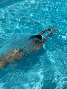 a woman swimming in a pool with no shirt on