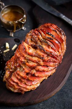 sliced ham on a wooden platter with sauce