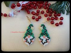 the beaded earrings are decorated with red balls and green beads, along with christmas decorations