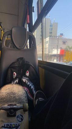 a skateboard and other items are sitting on the back of a bus in front of a window