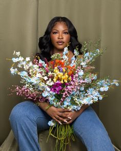 a woman sitting on a couch holding a bouquet of flowers