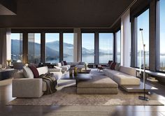 a living room filled with lots of furniture and large windows overlooking the mountains in the distance