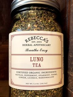 a jar filled with herbs sitting on top of a wooden table