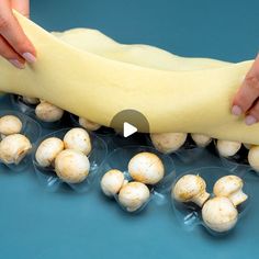 a person is placing mushrooms in plastic containers