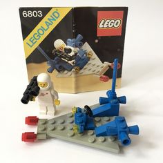 two legos are shown in front of a box with an astronaut and space shuttle on it