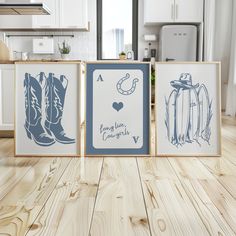 three framed pictures sitting on top of a wooden floor in front of a kitchen counter