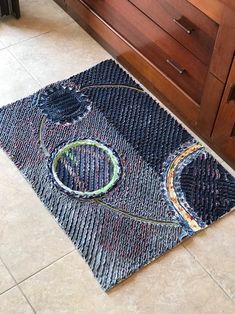 a blue rug with two circles on it in front of a wooden dresser and drawers