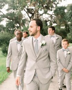 a group of men in suits walking down a path