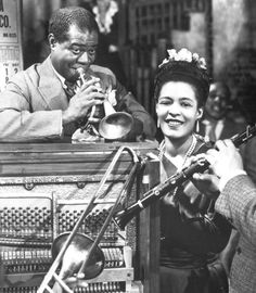 an old black and white photo of a woman playing the trumpet while two men look on