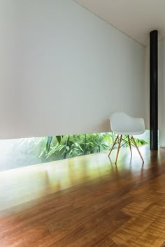 an empty living room with wood floors and white walls