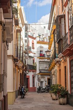 an alley way with several buildings and motorcycles parked on the side