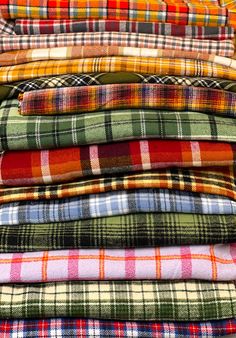 many different colored plaid shirts stacked on top of each other