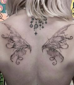 the back of a woman's shoulder with two wings on it