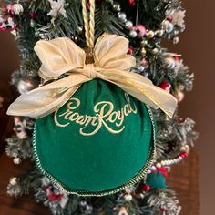 a green ornament hanging from a christmas tree