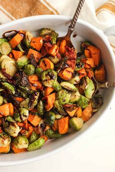 a bowl filled with brussel sprouts and sweet potatoes