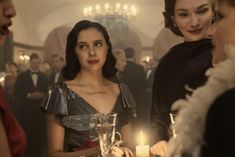 two women standing next to each other at a table with candles in front of them