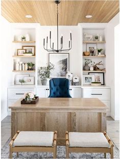 a dining room table with two chairs and a chandelier hanging from the ceiling