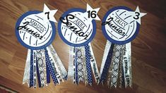 three blue and white award ribbons on a wooden floor with the words happy birthday written on them