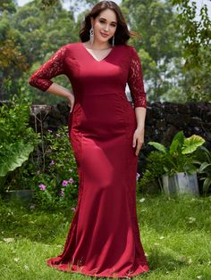 a woman in a red dress posing for the camera with her hands on her hips