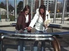 two girls are playing with an object in the park