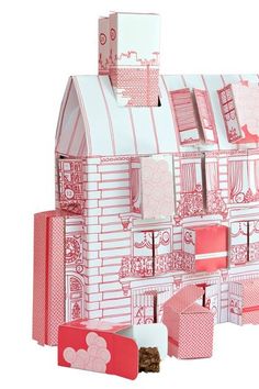 a pink and white paper doll house on a table