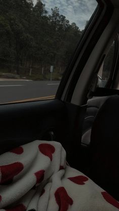 the interior of a car with red and white polka dot blankets in the passenger seat