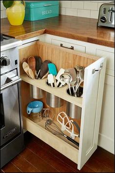 an open cabinet in a kitchen filled with utensils