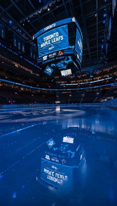 an empty ice rink with blue lights and signs on the ceiling in toronto maple leafs stadium