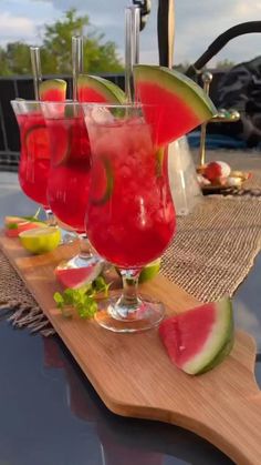 three glasses filled with watermelon and limeade sitting on top of a cutting board