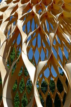 an intricate wooden sculpture is shown against the blue sky