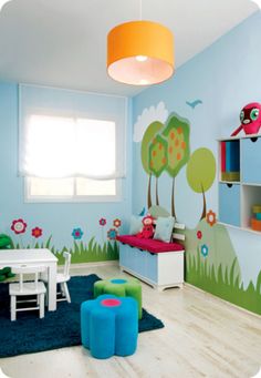 a child's room decorated in blue and green with trees, flowers, and birds painted on the walls