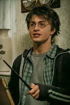 a young harry potter holding a wand in his hand