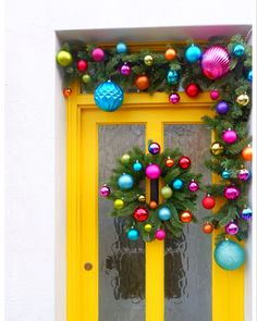 a yellow door decorated with christmas ornaments