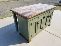 an outdoor kitchen island made out of wood and metal with two doors on each side