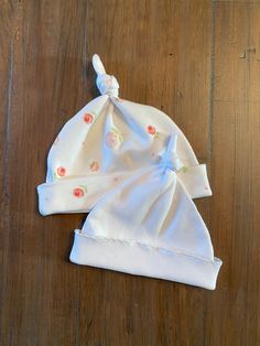 two baby hats sitting on top of a wooden floor