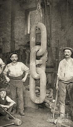 an old black and white photo of men standing in front of a large metal object