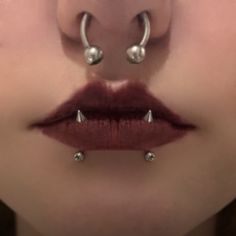 a woman's nose with two piercings on top of her lip and the bottom part of her mouth