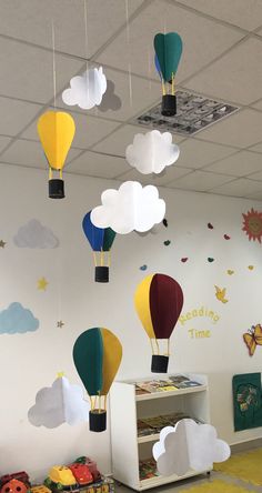 several hot air balloons are suspended from the ceiling in this children's playroom