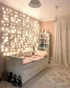 a bedroom with lights on the wall and a bed in front of a book shelf