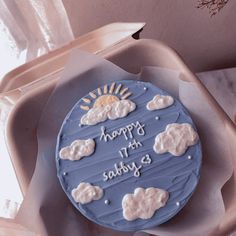 a birthday cake with frosting and clouds on it