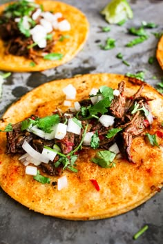 three tortillas with meat, onions and cilantro