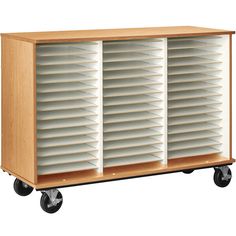 a large wooden storage unit with wheels on the front and bottom shelves that have white shutters