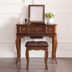 a wooden vanity with a mirror and stool