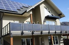 a house with solar panels on the roof and in front of it is a red frame