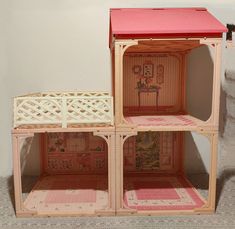 two wooden doll houses with pink roof and white trim on the top one has a red roof