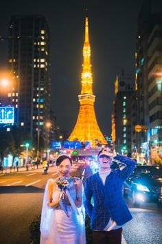 two people posing for a photo in front of the eiffel tower at night